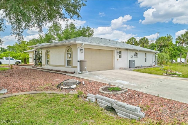 ranch-style house featuring cooling unit, a garage, and a front yard