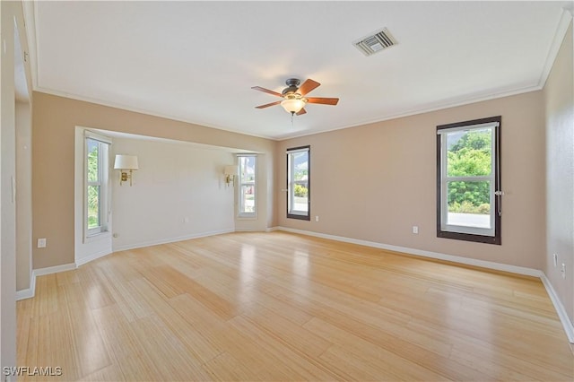 empty room featuring ceiling fan, ornamental molding, light hardwood / wood-style floors, and a wealth of natural light