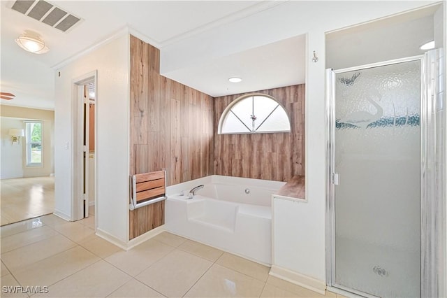 bathroom featuring plus walk in shower, tile patterned flooring, and wood walls