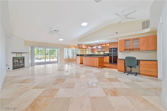 kitchen with ceiling fan, a center island, a breakfast bar, and black fridge with ice dispenser