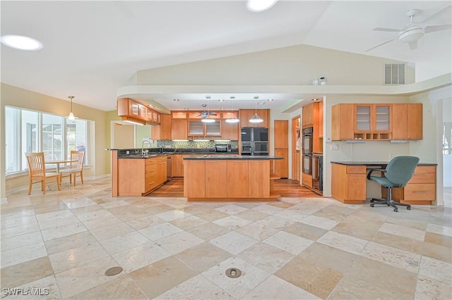 kitchen featuring lofted ceiling, sink, decorative light fixtures, a kitchen island, and black appliances