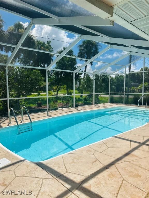 view of swimming pool with a patio and glass enclosure