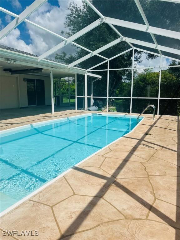 view of swimming pool featuring a patio and a lanai