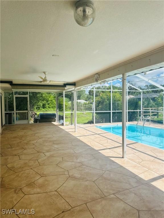 view of swimming pool featuring a patio and a lanai