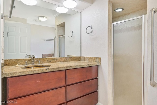 bathroom featuring vanity and a shower with door