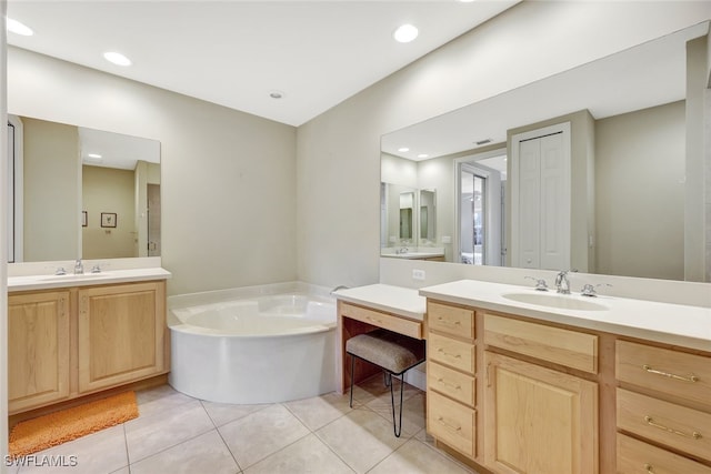 bathroom featuring tile patterned floors, a bathing tub, and vanity