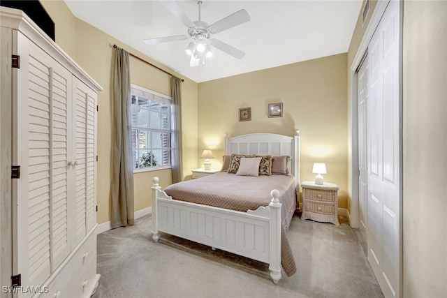 bedroom with ceiling fan, baseboards, a closet, and light carpet