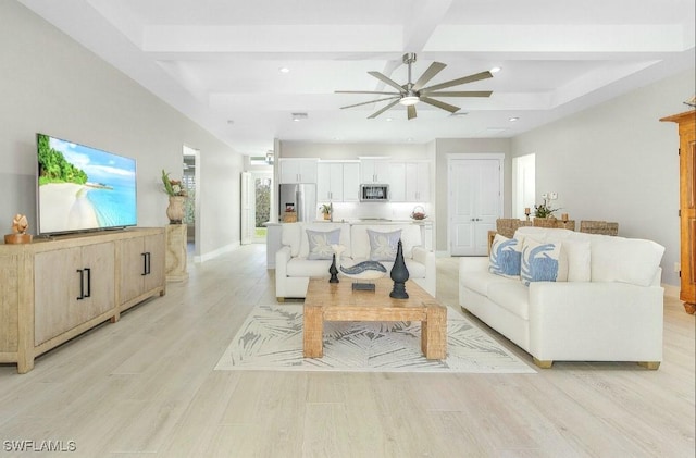 living room with beamed ceiling, ceiling fan, and light wood-type flooring