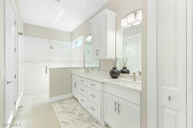 bathroom with vanity and a shower with door