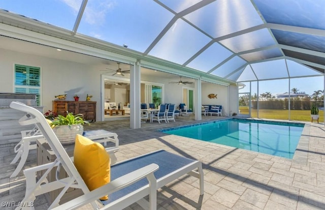 view of swimming pool featuring ceiling fan, a lanai, and a patio