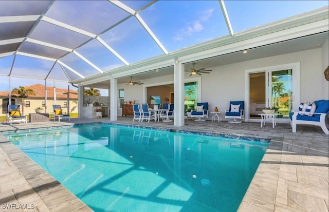 view of swimming pool with a patio, ceiling fan, and glass enclosure