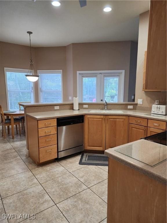 kitchen featuring pendant lighting, sink, stainless steel dishwasher, light tile patterned floors, and kitchen peninsula