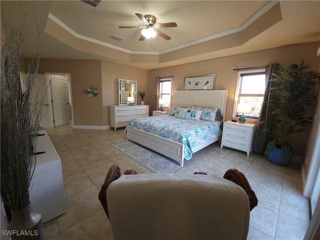 bedroom with a raised ceiling, ornamental molding, light tile patterned floors, and multiple windows