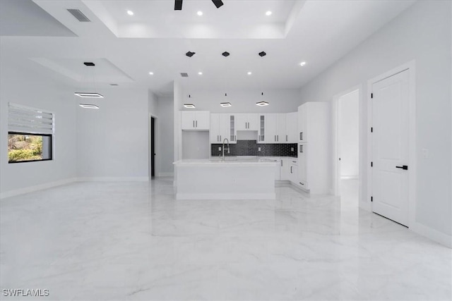 living room featuring sink, a raised ceiling, ceiling fan, and a high ceiling