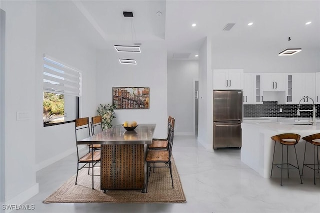 dining area featuring sink and a high ceiling