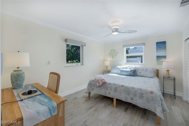 bedroom featuring ceiling fan, ornamental molding, and light wood-type flooring