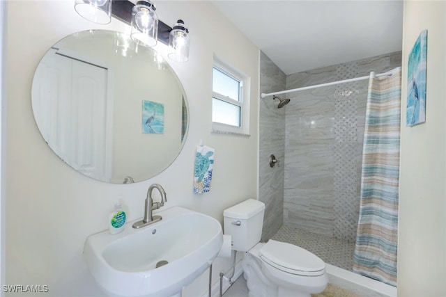 bathroom with a shower with shower curtain, toilet, and sink