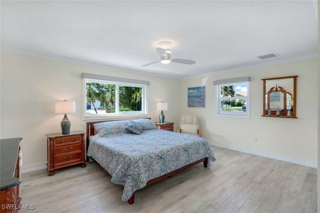 bedroom featuring multiple windows, crown molding, ceiling fan, and light wood-type flooring