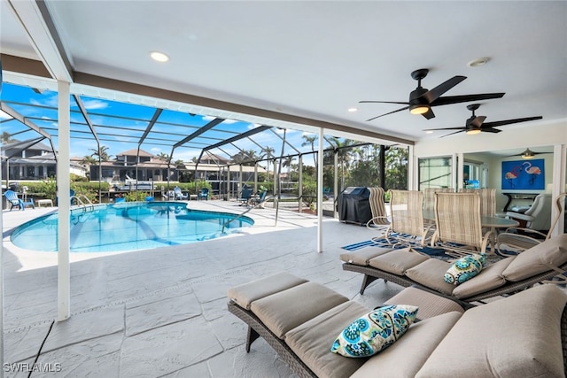 view of pool featuring a grill, a lanai, a patio area, and ceiling fan