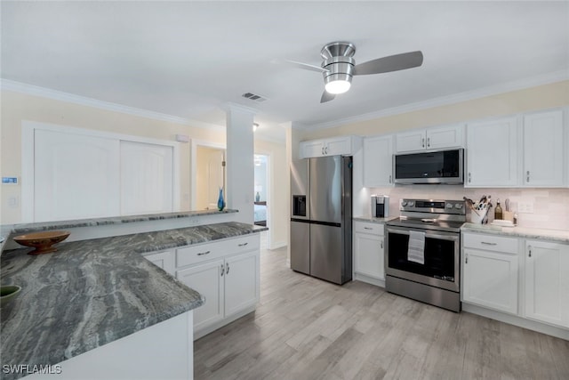 kitchen featuring white cabinetry, crown molding, light hardwood / wood-style flooring, dark stone counters, and stainless steel appliances