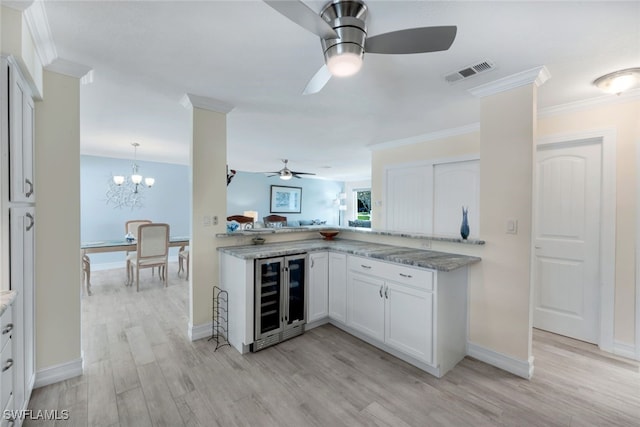 kitchen with wine cooler, light hardwood / wood-style flooring, ornamental molding, and white cabinets