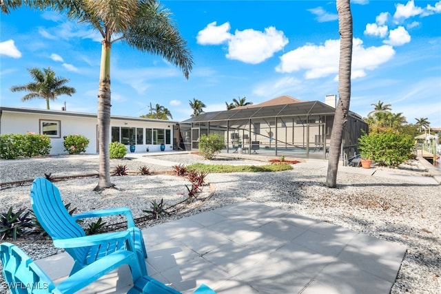 rear view of property with a lanai and a patio area