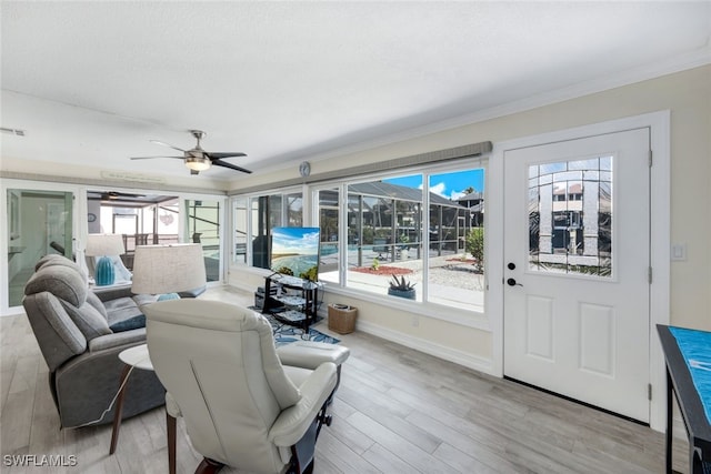 living room with crown molding, light hardwood / wood-style floors, ceiling fan, and a textured ceiling