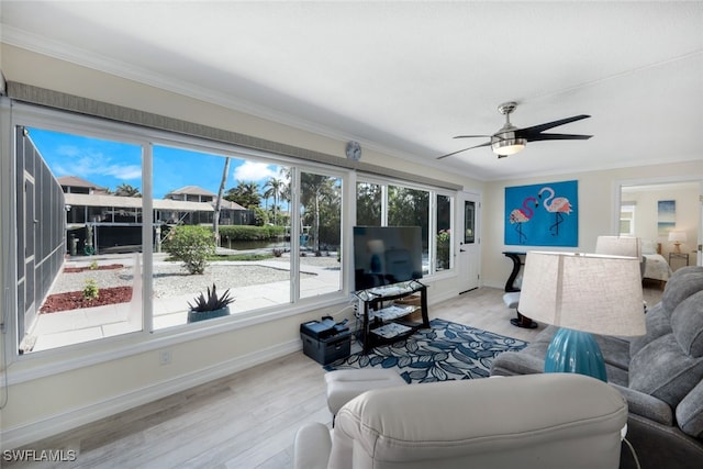 living room with crown molding, ceiling fan, and light hardwood / wood-style flooring