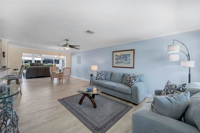 living room with crown molding, ceiling fan with notable chandelier, and light hardwood / wood-style flooring