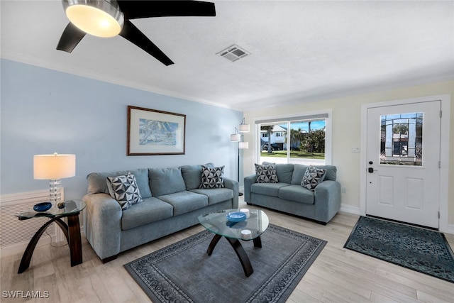 living room with crown molding, ceiling fan, and light wood-type flooring