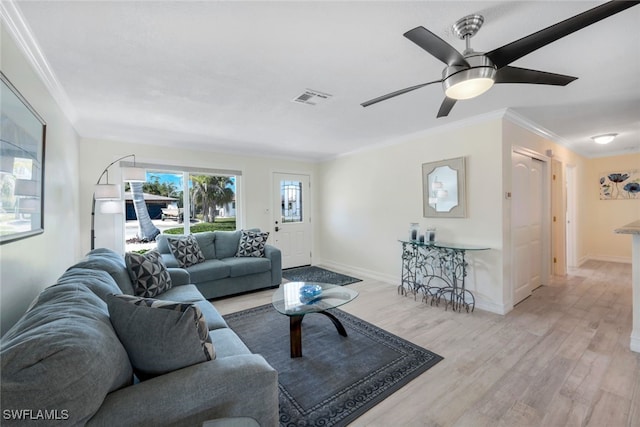 living room with ceiling fan, ornamental molding, and light hardwood / wood-style flooring