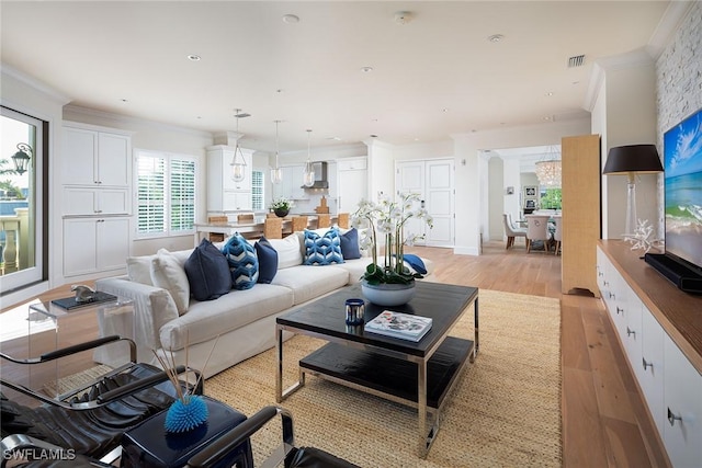 living room featuring ornamental molding and light hardwood / wood-style floors