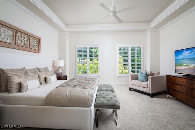 carpeted bedroom with a tray ceiling, ornamental molding, and ceiling fan