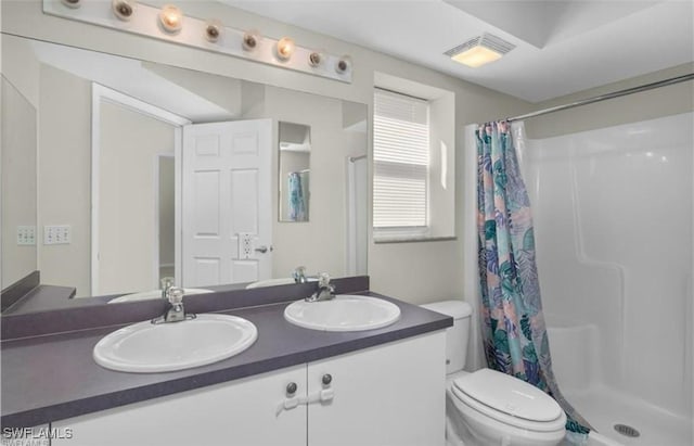 bathroom featuring vanity, toilet, and a shower with shower curtain