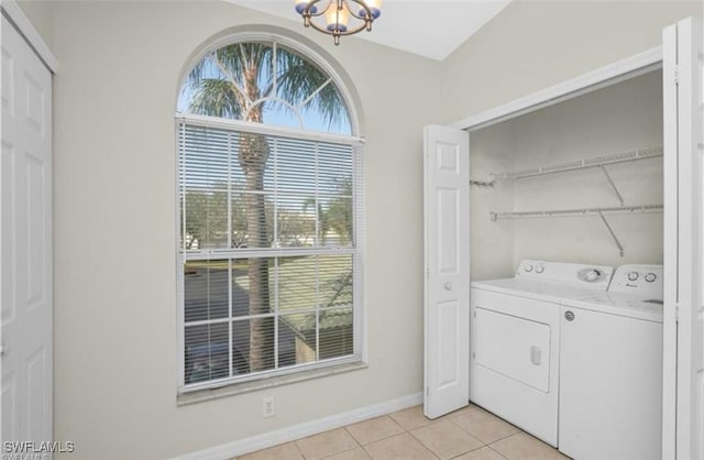 clothes washing area featuring light tile patterned flooring, independent washer and dryer, and a chandelier