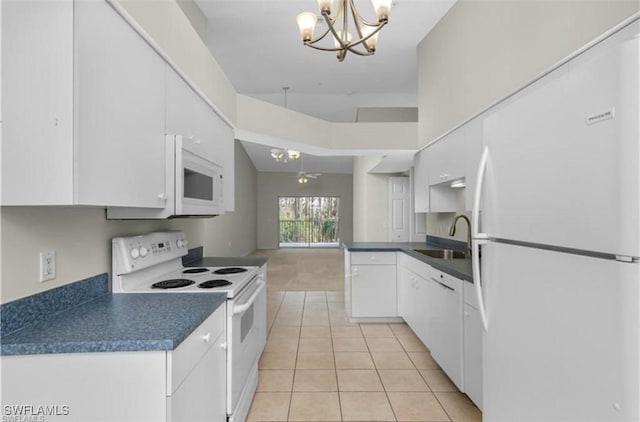 kitchen with sink, an inviting chandelier, decorative light fixtures, white appliances, and white cabinets