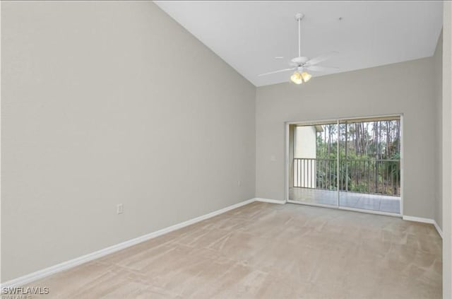 empty room featuring ceiling fan, high vaulted ceiling, and light carpet