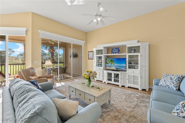 living area featuring a ceiling fan, a wealth of natural light, and wood finished floors