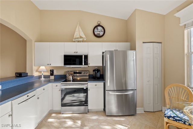 kitchen with stainless steel appliances, dark countertops, and white cabinets