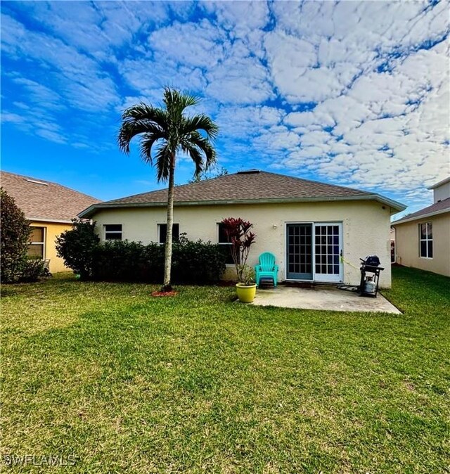 rear view of house with a yard and a patio