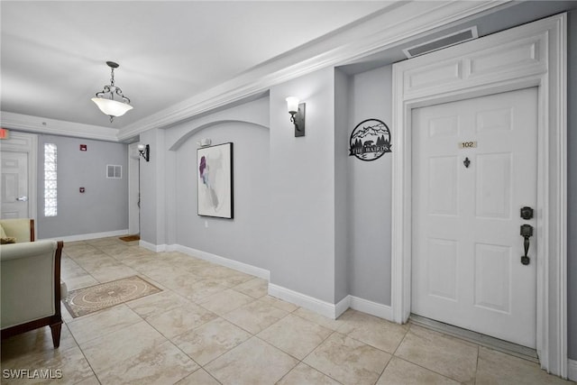 tiled entrance foyer featuring ornamental molding