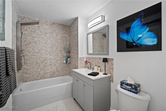 full bathroom featuring tiled shower / bath, vanity, toilet, and tile walls