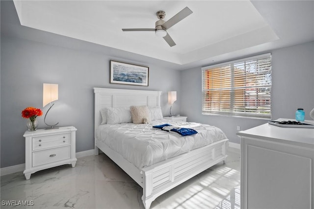 bedroom with a tray ceiling and ceiling fan