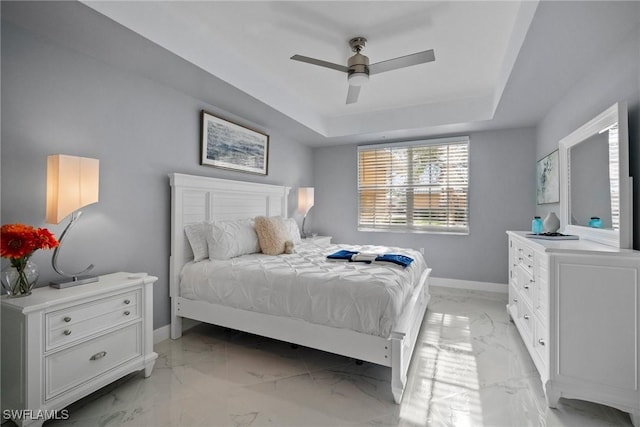 bedroom featuring ceiling fan and a tray ceiling