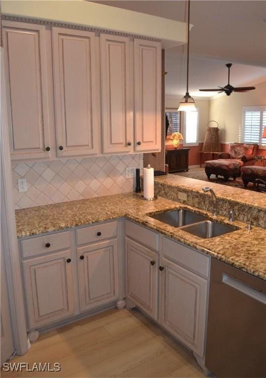 kitchen featuring sink, dishwasher, pendant lighting, ceiling fan, and backsplash