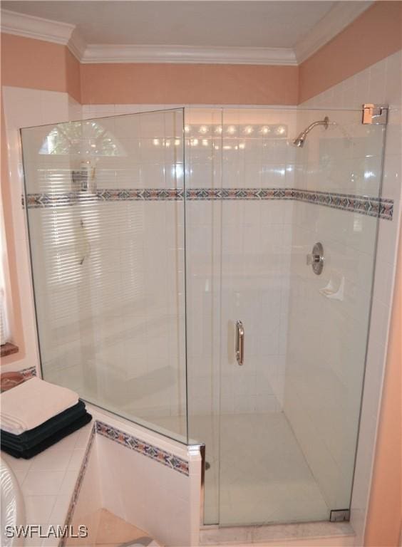 bathroom with a shower with door and ornamental molding