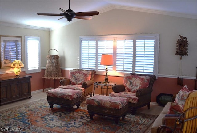 living area with ornamental molding, lofted ceiling, wood-type flooring, and ceiling fan