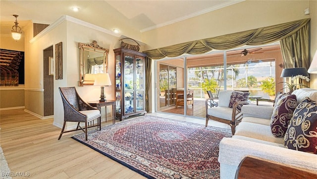 sitting room featuring crown molding, a sunroom, ceiling fan, wood finished floors, and baseboards