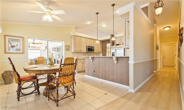 kitchen with lofted ceiling, ceiling fan, stainless steel appliances, ornamental molding, and decorative light fixtures