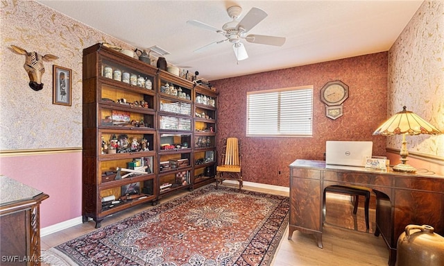 office area featuring wallpapered walls, ceiling fan, baseboards, and wood finished floors